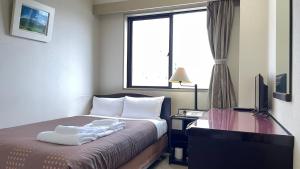 米子市HOTEL FRONTIER YONAGO (ホテルフロンティア米子)的酒店客房,配有床和电视
