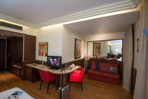 坎比亚戈AS酒店的客房设有一张书桌、一台电脑和一张红色沙发