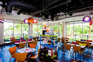 温特黑文佛罗里达州乐高乐园®度假酒店的餐厅设有多彩的桌椅和窗户。