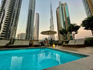 迪拜Fabulous 2BR l High Floor l by Burj Khalifa & Dubai Mall I Pool I Gym的一座位于城市中心,拥有高楼建筑的游泳池