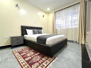 纳库鲁Naka Executive Suites With Balcony, Amazing Lake Nakuru View, GYM的一间卧室配有一张大床和地毯。