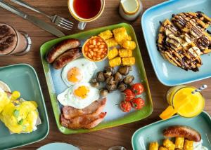 米尔福德昂西Shorefield Country Park的一张桌子,上面有一盘早餐食品,包括鸡蛋土豆和其他食物