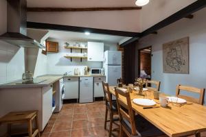 RubialesApartamentos Econatur的厨房以及带木桌和椅子的用餐室。