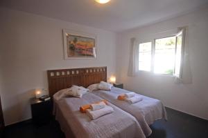 卡拉加尔达纳Villa Can Bella, 350m zum Strand的一间卧室配有两张带毛巾的床
