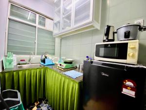 波德申Izdisa Muslim Homestay Teluk Kemang Groundfloor unit with Pool view的厨房配有冰箱上方的微波炉