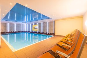 米特尔贝格克林瓦萨特IFA阿尔彭罗斯酒店的酒店客房的大型游泳池配有椅子