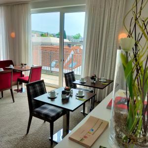 莱茵河畔因格尔海姆英格尔海姆IBB酒店的酒店客房设有桌椅和大窗户。