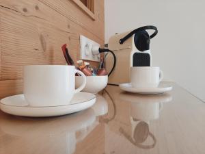 勒米尔蒙Chambre privée Au pied des Vosges的厨房里的2个咖啡杯放在柜台上