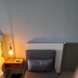 阿吉亚特拉萨佛得角旅馆的一间卧室配有椅子和一个带灯的床头柜