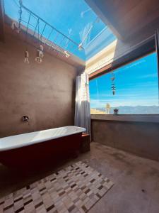 乌鲁比西Cabana Monte - Pousada Colina dos Ventos的带浴缸和大窗户的大浴室