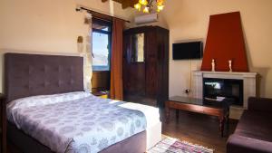 Dhamavólosvilla Morfeas的一间卧室配有一张床、一张桌子和一个壁炉