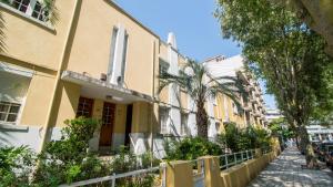 波尔图Oporto Yellow Villas的棕榈树和围栏的街道上的建筑