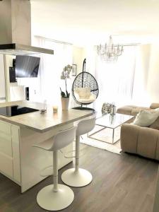 沃昂夫兰Appartement 65m2 avec terrasse privé & jacuzzi的厨房以及带桌子和沙发的客厅。