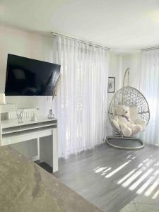 沃昂夫兰Appartement 65m2 avec terrasse privé & jacuzzi的客房设有电视、椅子和书桌。