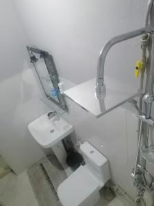拉希迪耶HOTEL ERRACHIDIA的白色的浴室设有水槽和卫生间。