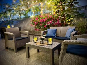 里奥阿托Beach villa with cozy terrace的庭院设有藤椅和桌子,种有鲜花
