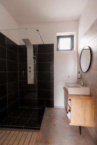 托普利察Zenstay ApartHotel的带淋浴、盥洗盆和镜子的浴室