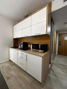 科沃布热格NCM Apartments Seaside Park的厨房配有白色橱柜和微波炉