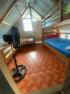 科隆Cabaña La Punta的一间卧室设有阁楼,配有一张床和风扇