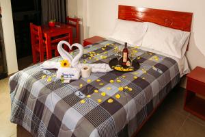 瓦努科YURAQ WASI Hotel/Restobar的一张带食物托盘和一瓶香槟的床铺