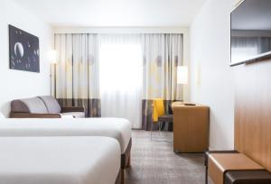 马尼·莱斯·阿莫Novotel Saint-Quentin en Yvelines的酒店客房,设有两张床和一张沙发