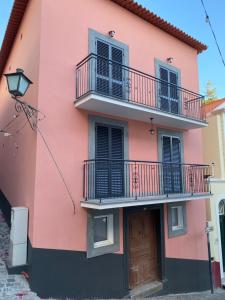 蓬他达维托亚Alojamento Príncipe D.Luís的粉红色的建筑,设有阳台和门