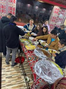 瓦迪拉姆Wadi Rum albasli的一群坐在餐桌上吃食物的人
