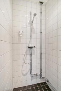 斯德哥尔摩布拉恩拜酒店的白色瓷砖浴室内的淋浴