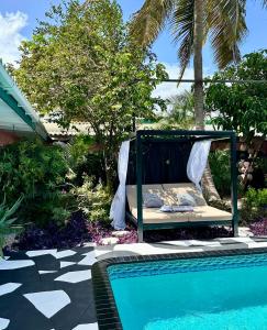 威廉斯塔德THUISHAVEN boutique mini-resort - fantastic garden and large pool - adults only的游泳池畔的一张床