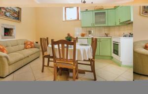 BičićiLovely Home In Barban With Kitchen的一间带桌子的客厅和一间带绿色橱柜的厨房
