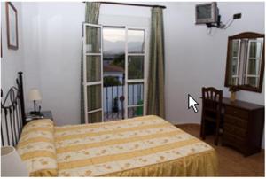 皮萨拉Hostal Adrian的一间卧室设有一张床和一个大窗户