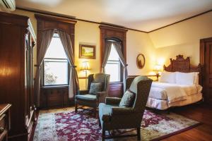 阿什维尔Cedar Crest Inn的酒店客房,配有一张床和两把椅子