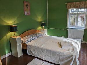 于尔岑„Altes Forsthaus“ am Schloss的一间绿色卧室,配有一张床和两盏灯
