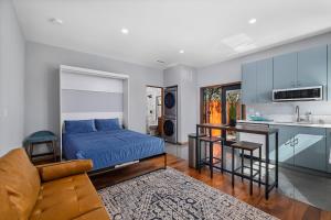 拉米萨Private Studio in La Mesa的一间带蓝色床的卧室和一间厨房
