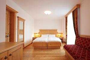 多比亚科格玛尼亚公寓式酒店的一间卧室配有一张床和一张红色的沙发
