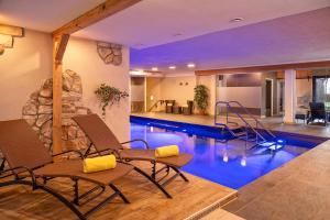 上施陶芬蒂罗尔酒店的一座带椅子的别墅内的游泳池和一座游泳池