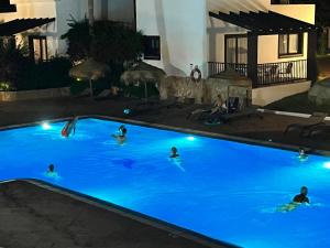 卡兰博希Nuramar Resort & Villas的一群人晚上在游泳池游泳