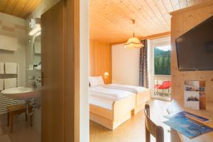 多比亚科格玛尼亚公寓式酒店的一间卧室配有床、水槽和窗户