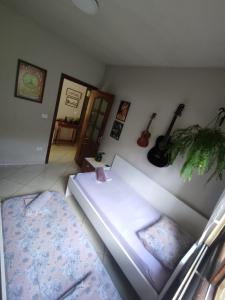 伊达贾伊Quarto Felicidade Cabeçudas的一间墙上有一张床和吉他的房间