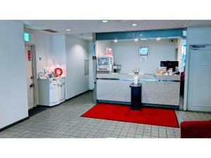 千叶Hotel Tetora Makuhari Inagekaigan - Vacation STAY 90828v的商店的大厅,有柜台和红色地毯