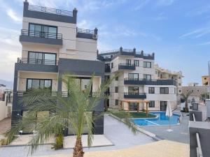 沙姆沙伊赫Montazah seaside homes的一座大型建筑,前面设有一个游泳池