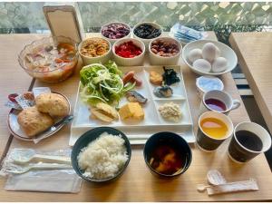 千叶Hotel Tetora Makuhari Inagekaigan - Vacation STAY 91509v的餐桌上放着食物和碗