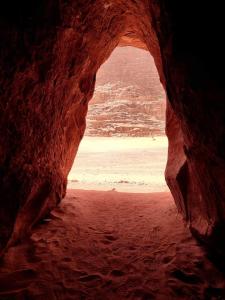 瓦迪拉姆wadi rum fox road camp & jeep tour的洞穴享有海滩美景