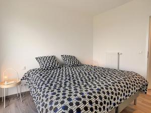 瑟兰Magnifique appartement 2 chambres à Liège Ougrée的一间卧室配有一张带黑白色棉被的床