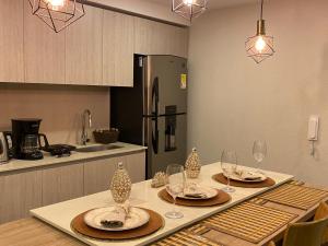 卡塔赫纳Dominique Cartagena, Beautiful 2 Bedroom Apartment的厨房配有带盘子和酒杯的桌子