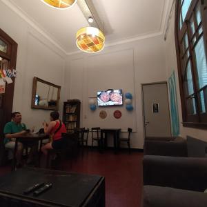 布宜诺斯艾利斯Play Hostel Arcos的两个人坐在一个房间里桌子上