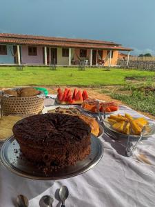 路易斯科雷亚Pousada Barlavento的一张桌子,上面放着巧克力蛋糕和水果