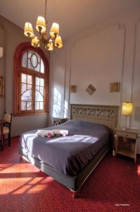 布宜诺斯艾利斯Play Hostel Arcos的一间卧室设有一张床、一个窗户和一个吊灯。