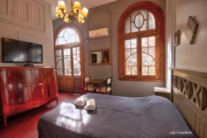 布宜诺斯艾利斯Play Hostel Arcos的一间卧室设有一张床、一台电视和两个窗户。