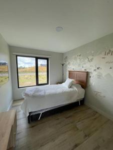 延基韦Casa de campo familiar, Puerto Varas Chile的一间卧室设有一张大床和一个窗户。